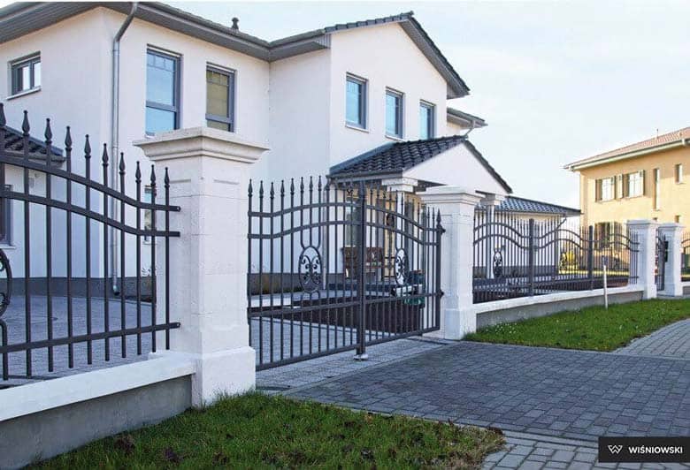 Dwuskrzydłowa brama stylizowana na kutą marki Wiśniowski dopasowana do paneli ogrodzeniowych tej samej firmy.